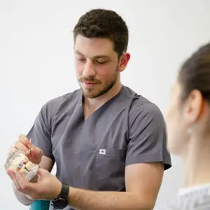 Dentist explaining veneers and implants to a patient