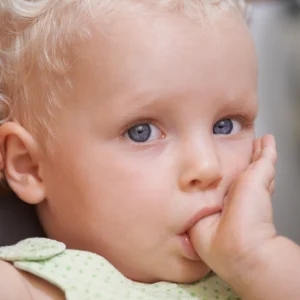 Baby sitting while sucking his thumb